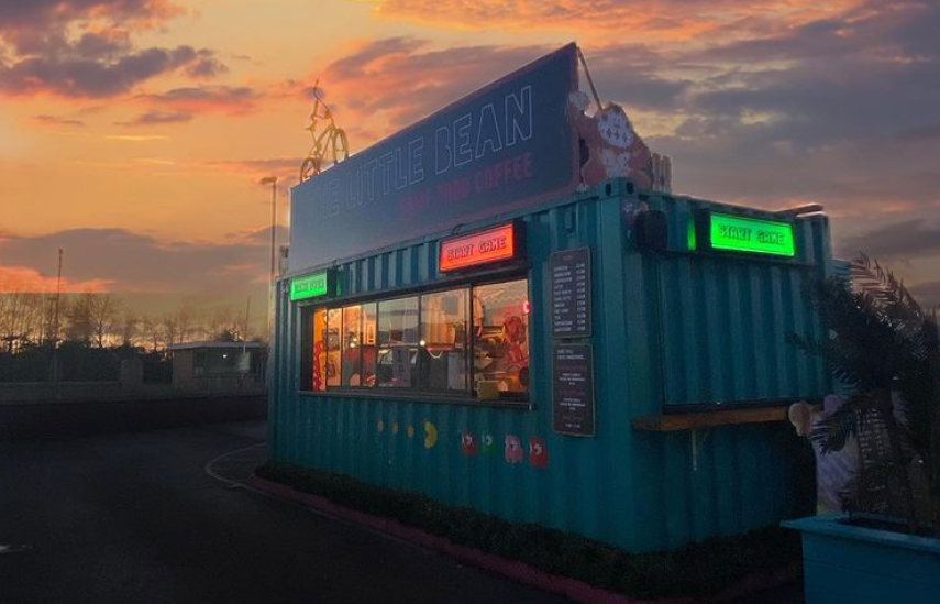 drive-thru coffee container against a cloudy sky at sunset