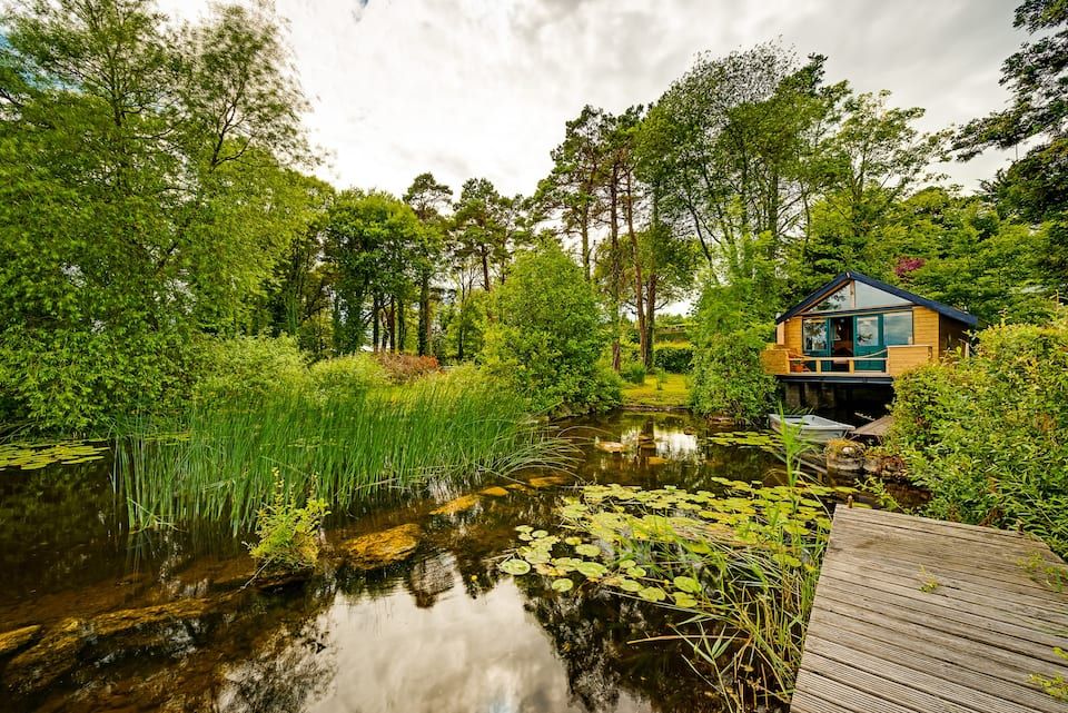 a log cabin on the banks of a lake for staycations in Ireland