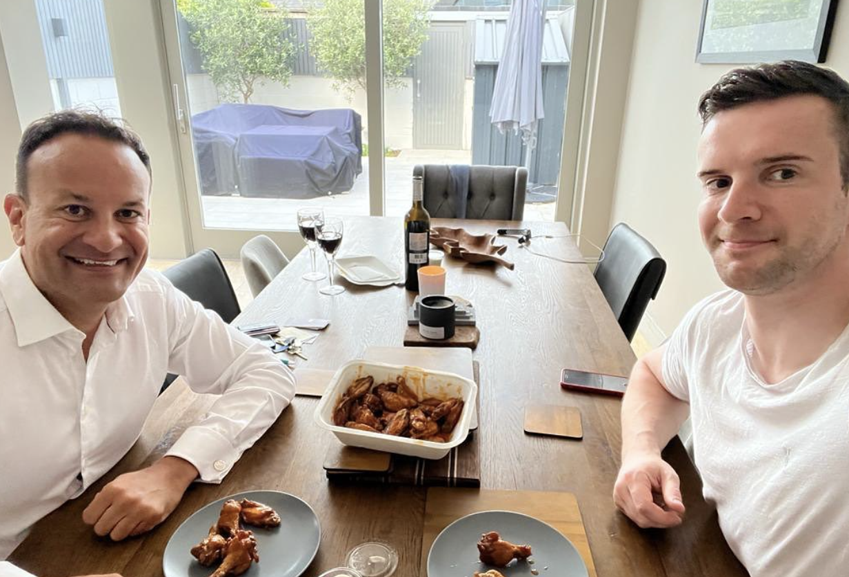 Leo Varadkar and his partner smiling with a serving of chicken wings on a table in between them