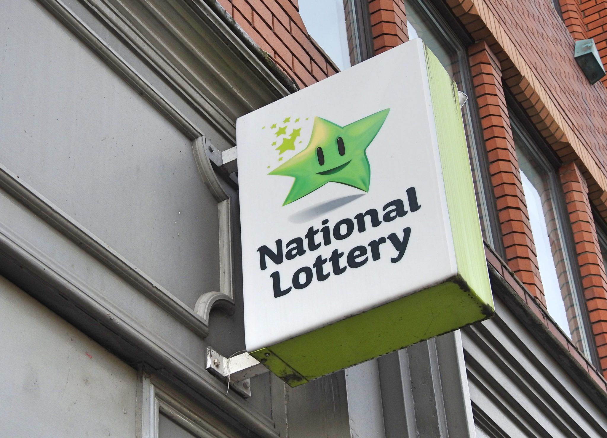 national lottery sign hanging outside a shop