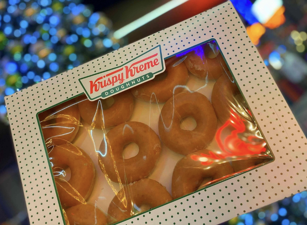 multipack of krispy kreme donuts with christmas lights in the background