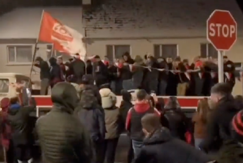 people throwing snowballs at sports team traveling on an open-top lorry