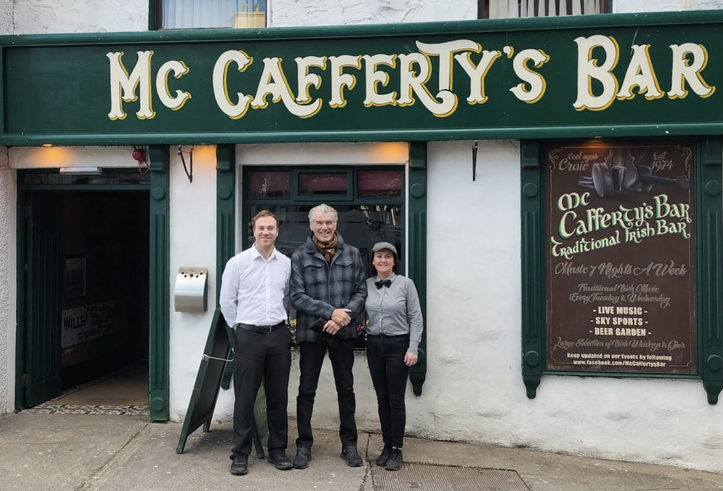 Pierce Brosnan posing for a picture with staff outside McCafferty's Bar in Donegal